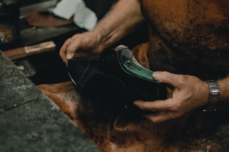 Cobbler hands inspecting a leather shoe
