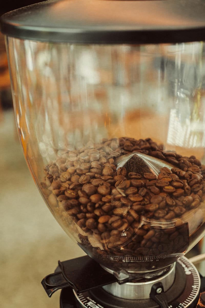 Coffee beans in a transparent grinder, ready for grinding