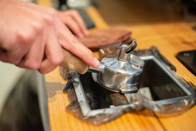 Cleaning the portafilter in a knock box, the barista daily routine