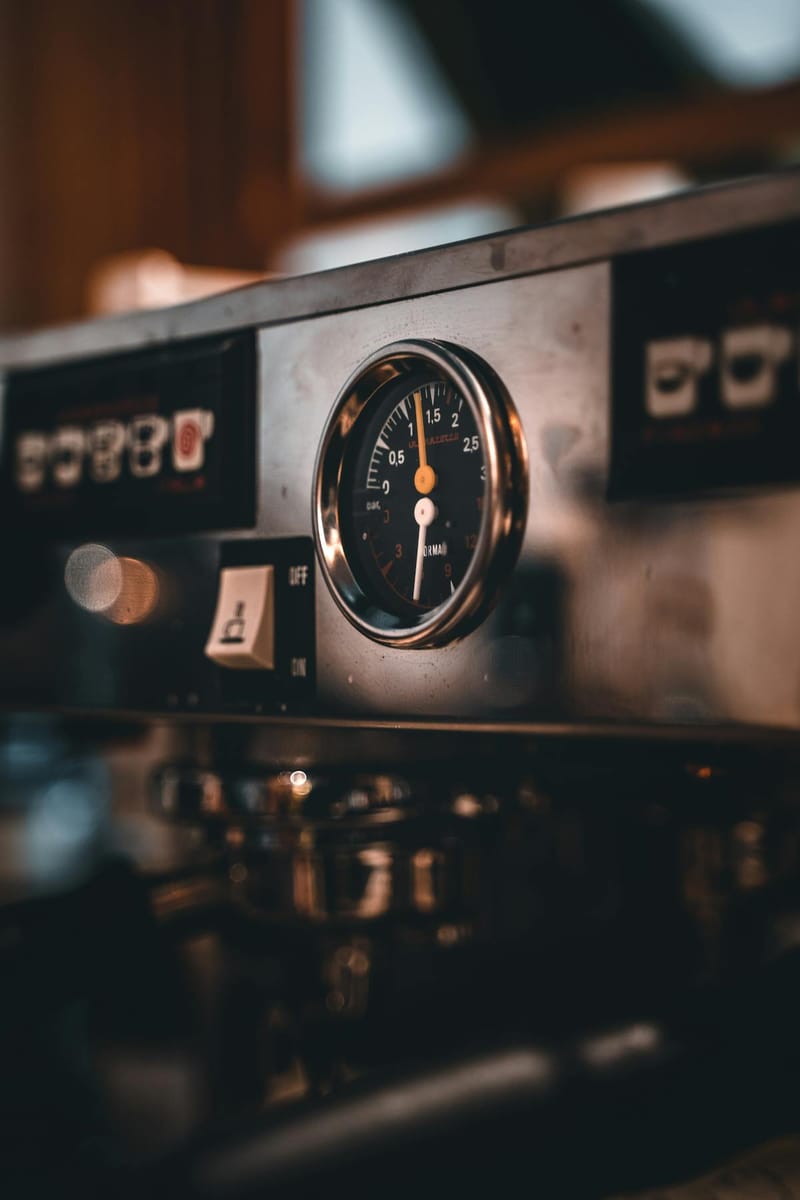Pressure gauge on an espresso machine, moody lighting