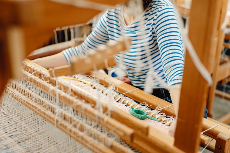 Weaver in Breton stripe shirt at the loom