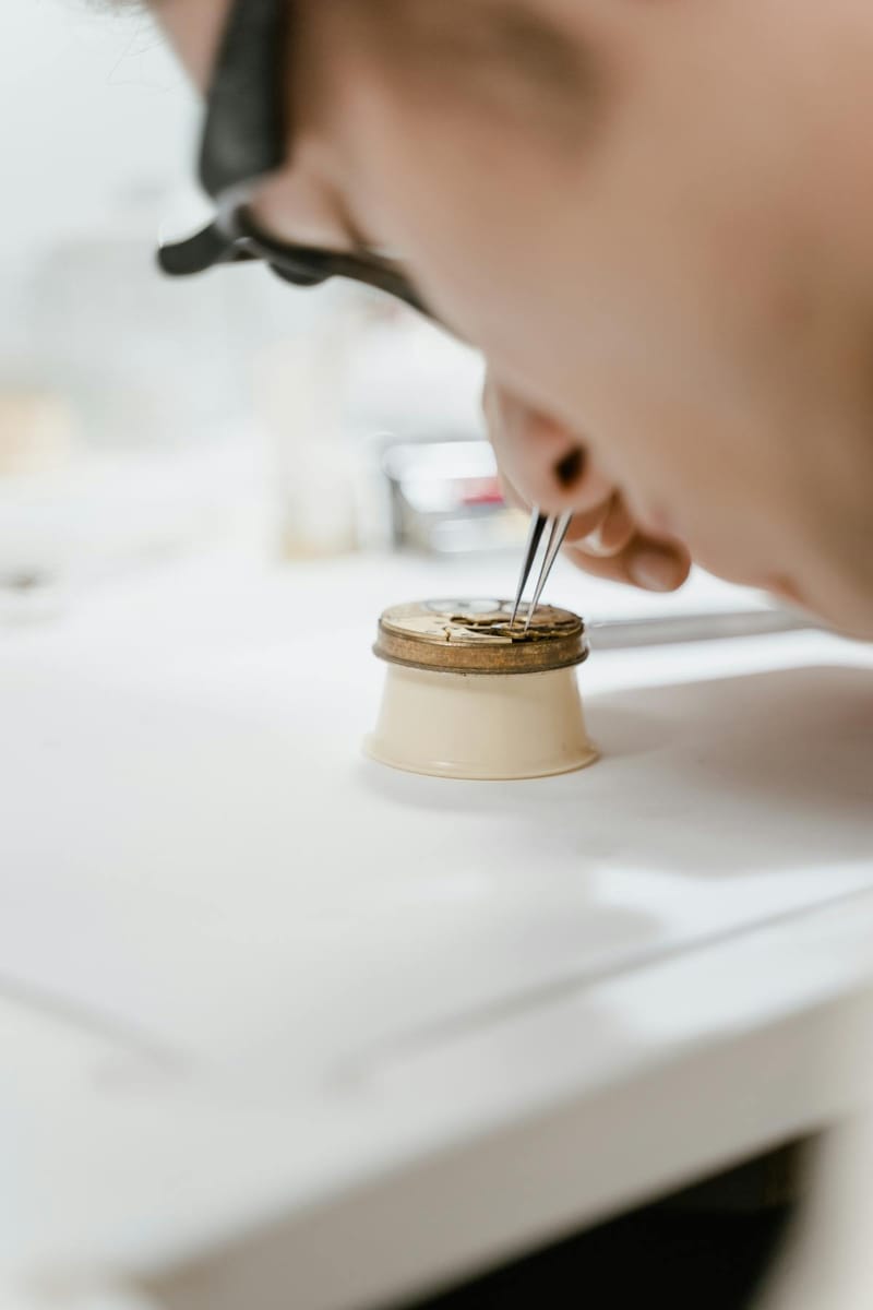 Horloger manipulant des composants avec une pince fine